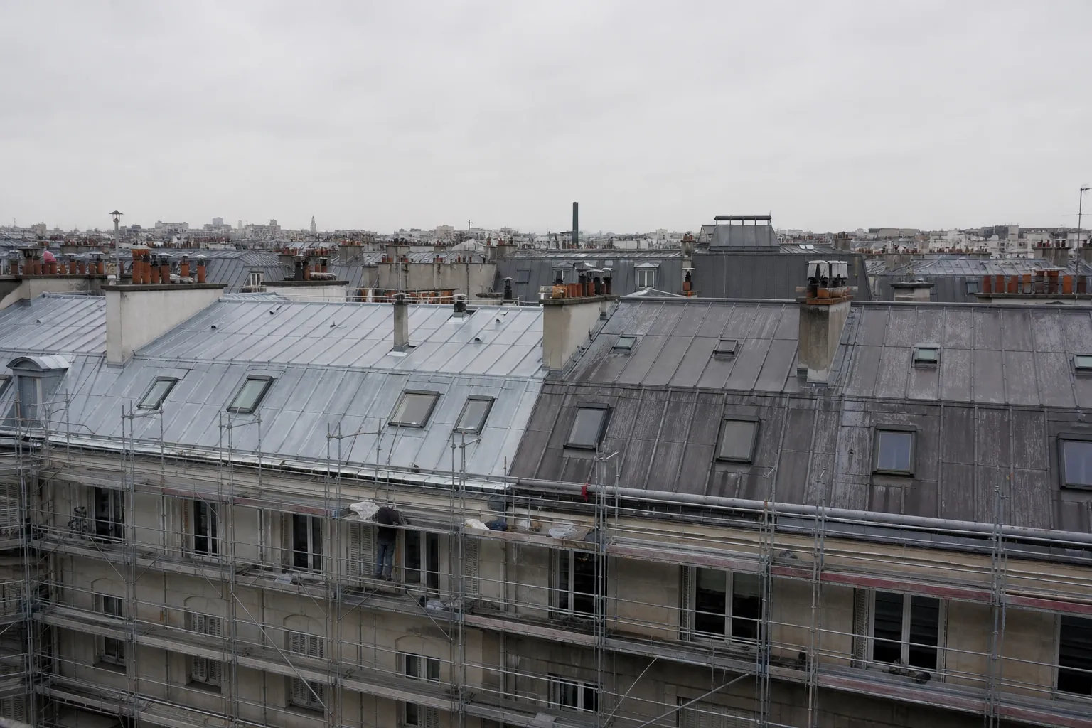 Toiture d’immeuble parisien en cours de rénovation, moitié de zinc neuf clair et moitié de zinc patiné