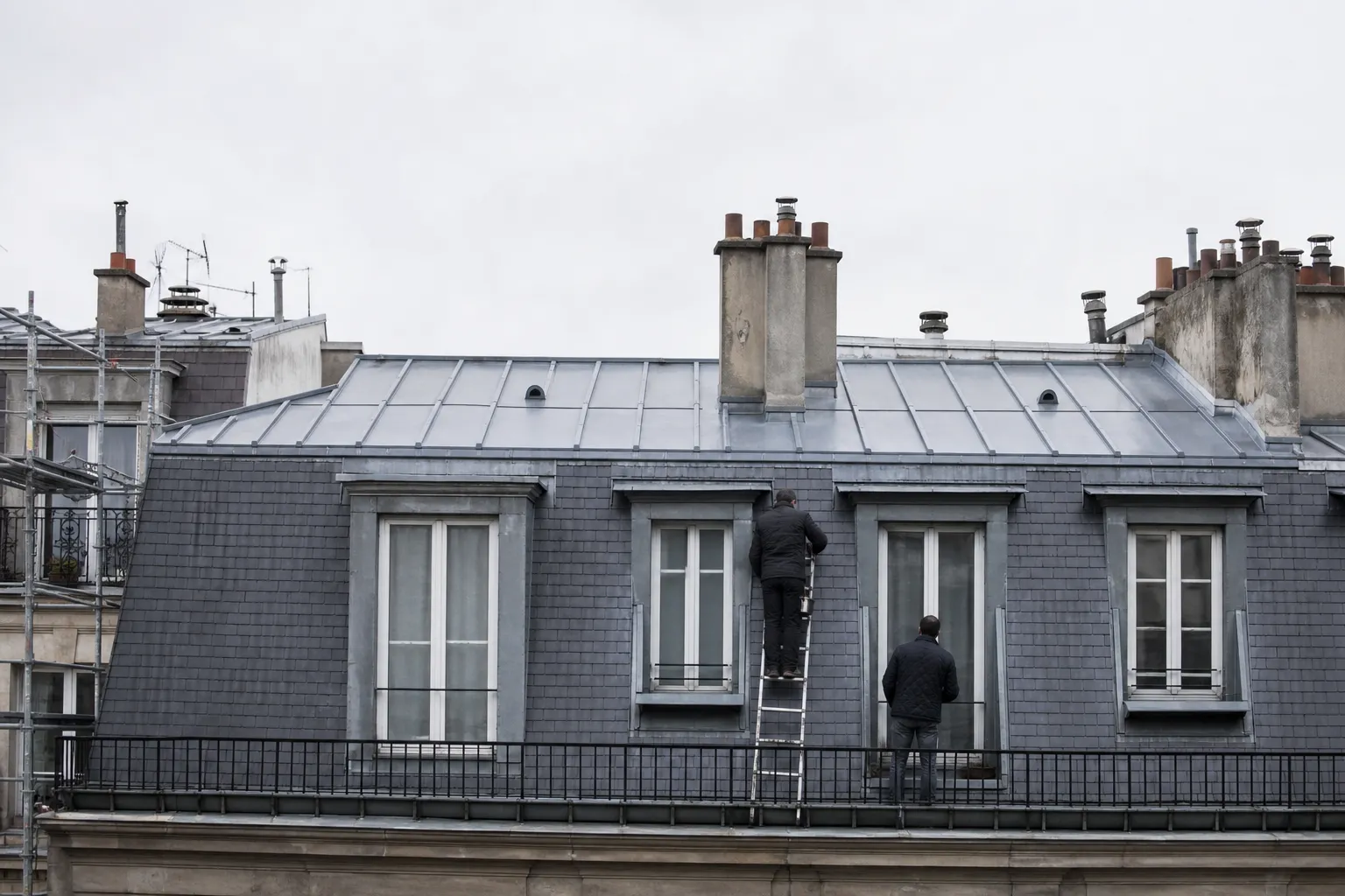 Brisis d’un comble parisien recouvert d’ardoises neuves posées en rangs réguliers, terrasson en zinc au-dessus