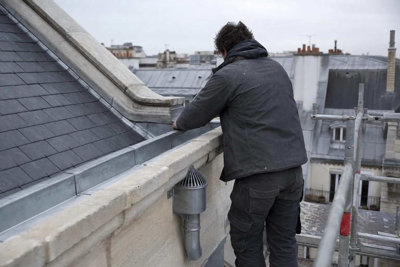 Chéneau de zinc reconstruit derrière une corniche, soudures fraîches et crapaudine posée sur la naissance
